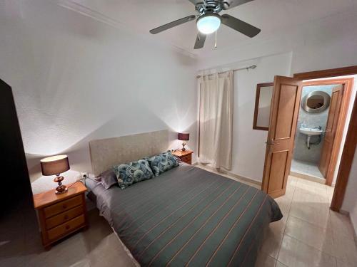 a bedroom with a bed and a ceiling fan at Amplio con Patio y vistas a la Plaza in Dolores