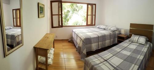 a small room with two beds and a window at Casa do Lago in Cunha