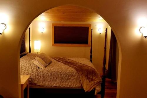 a bedroom with a bed in an archway with two lights at Farmview Cottage at White Lotus Eco Spa Retreat in Stanardsville