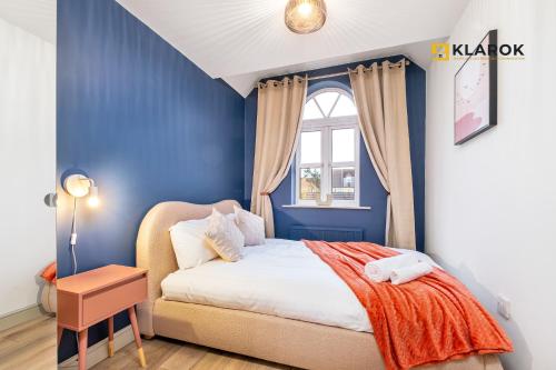 a blue bedroom with a bed and a window at 30% OFF 28 Nights+ 3bed House - Klarok - Peterborough in Peterborough