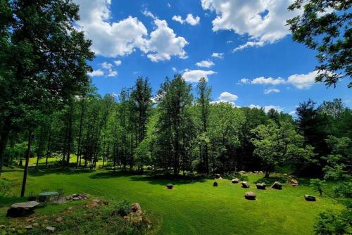 a group of animals grazing in a field with trees at Zen River Retreat in Stanardsville