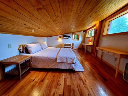 um quarto com uma cama grande e um tecto de madeira em Zen River Retreat em Stanardsville