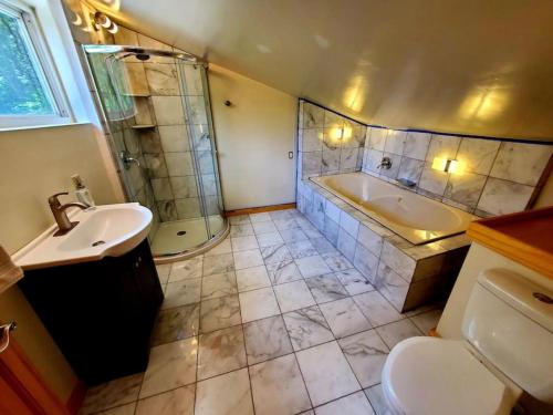 a bathroom with a sink and a tub and a toilet at Zen River Retreat in Stanardsville
