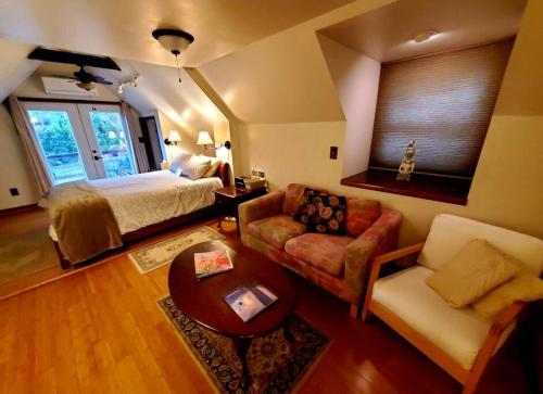 a bedroom with a bed and a couch and a table at Balcony Suite at White Lotus Eco Spa Retreat in Stanardsville