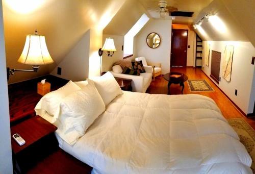 ein Schlafzimmer mit einem großen weißen Bett und ein Wohnzimmer in der Unterkunft Balcony Suite at White Lotus Eco Spa Retreat in Stanardsville