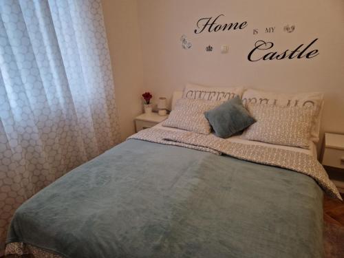 une chambre avec un lit et un panneau indiquant que la maison est mon château dans l'établissement Apartment Marina, à Vinkovci