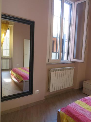 a mirror in a room with two beds and a window at Casa Luna tra Como e Milano in Saronno