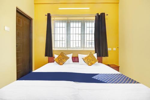 a bedroom with a large bed with a window at SPOT ON Kayal Residency in Coimbatore
