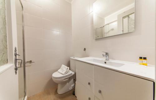 a white bathroom with a toilet and a sink at A41- Olive Tree Street 1 Bed Flat in Lagos
