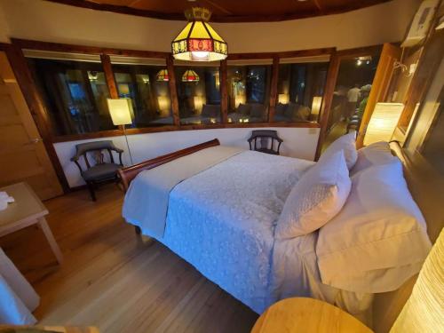 een slaapkamer met een bed, een kroonluchter en ramen bij Crows Nest in Stanardsville