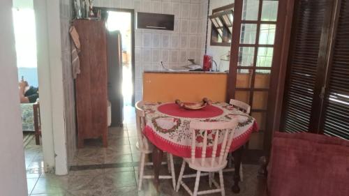 a table in a kitchen with a red and white table cloth at Casa no paraíso Búzios! in Búzios