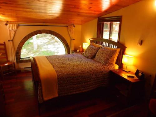 una camera da letto con un letto e una grande finestra di Suite Pea at White Lotus Eco Spa Retreat a Stanardsville