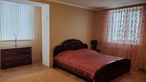a bedroom with a bed and a dresser and a window at Lenina 7 in Tiraspol