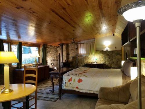 a bedroom with a bed and a table and a couch at Castle Suite at White Lotus Eco Spa Retreat in Stanardsville