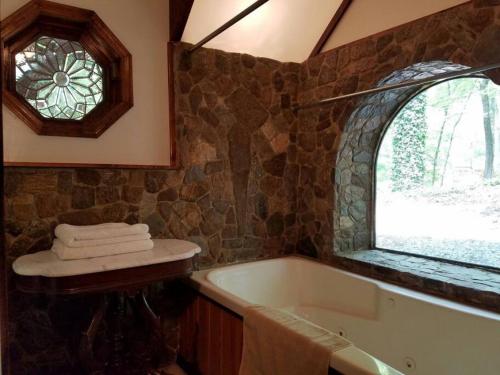 uma casa de banho com uma banheira e uma janela em Castle Suite at White Lotus Eco Spa Retreat em Stanardsville