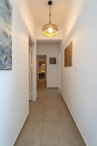 a hallway with white walls and a light fixture at BLUE WATERS MYKONOS in Ornos