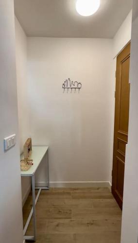 Cette chambre blanche dispose d'une table et d'une porte. dans l'établissement Charmant 3 pièces idéalement situé, à Menton