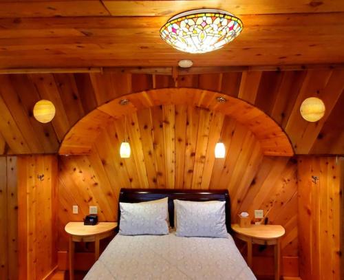a bedroom with a bed in a wooden room at Glade Cottage at White Lotus Eco Spa Retreat in Stanardsville