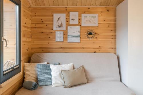 a bedroom with a wooden wall and a bed with pillows at Bursztynowo Mikoszewo in Mikoszewo