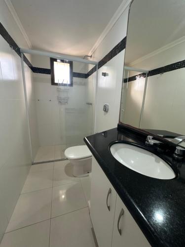 y baño con lavabo, aseo y espejo. en Apartamento com ótima vista para o mar em BC, en Balneário Camboriú