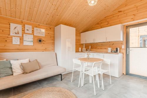 a kitchen and living room with a couch and a table at Bursztynowo Mikoszewo in Mikoszewo