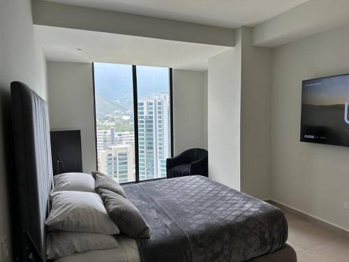 1 dormitorio con 1 cama y TV de pantalla plana en Lujoso departamento en San Pedro, en Monterrey