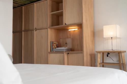 a bedroom with a bed and a table and a lamp at Vitaminas - Casa de Playa y Café in Punta del Este