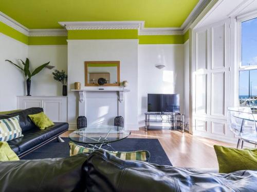a living room with a couch and a table at Longsands Beach Apartment 1 Tynemouth Free Onsite Parking in Tynemouth