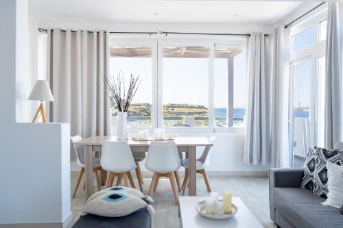 a living room with a table and chairs and a couch at BLUE WATERS MYKONOS in Ornos