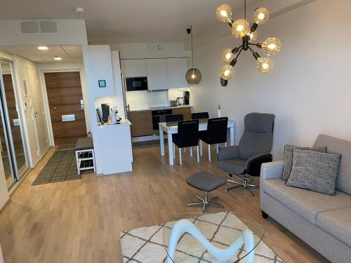 a living room with a couch and chairs and a kitchen at Tampere City view near Nokia Arena AC in Tampere