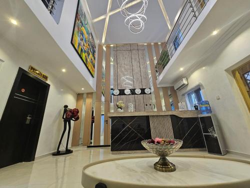 una stanza con un tavolo con una ciotola di fiori sopra di Extreme Royal Hotel and Suites a Lagos