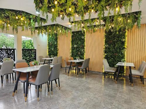 un restaurante con mesas, sillas y plantas en Extreme Royal Hotel and Suites, en Lagos