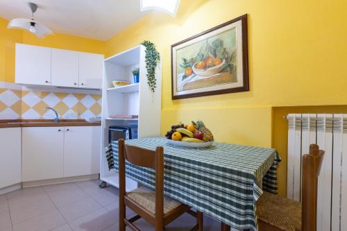 a kitchen with a table with a bowl of fruit on it at Villa Vacanze Paradiso - Oasi di Tranquillità con Piscina e Giardino a 10 min dal mare in Neviano