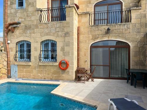une maison avec une piscine à côté d'un bâtiment dans l'établissement 4 Bedroom Holiday Home with Private Pool & Views, à Xewkija