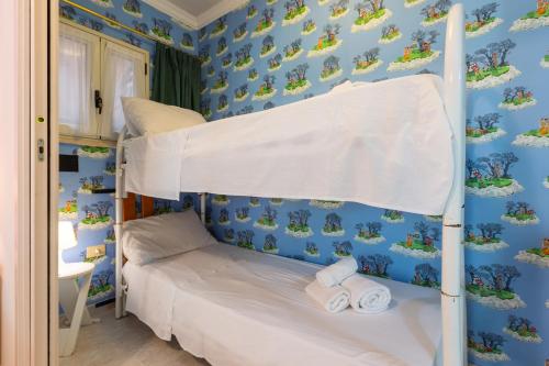 a bedroom with a bunk bed with blue walls at Villa Vacanze Paradiso - Oasi di Tranquillità con Piscina e Giardino a 10 min dal mare in Neviano