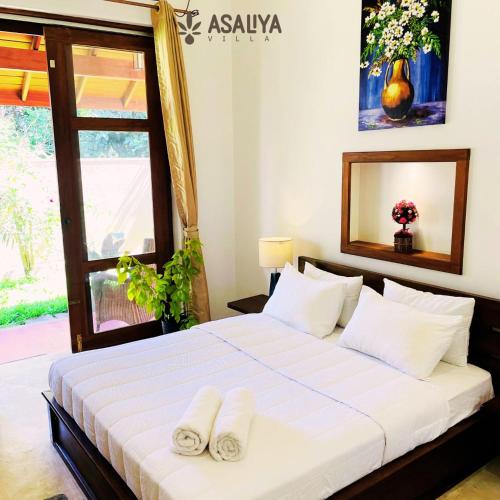 1 dormitorio con 1 cama con 2 toallas en Asaliya Villa, en Aswalapitiya