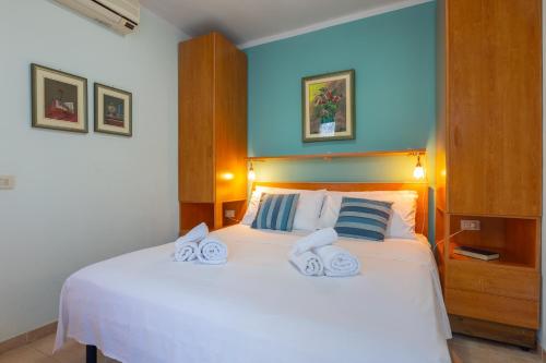 a bedroom with a white bed with towels on it at Villa Vacanze Paradiso - Oasi di Tranquillità con Piscina e Giardino a 10 min dal mare in Neviano