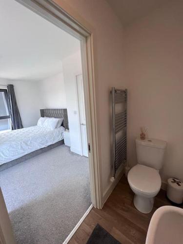 a bathroom with a toilet and a bed at Canterbury Penthouse: HUGE 2 bed ensuite + balcony in Canterbury