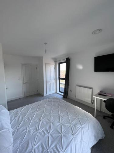 Canterbury Penthouse: HUGE 2 bed ensuite + balcony في كانتربيري: غرفة نوم بيضاء كبيرة مع سرير ومكتب