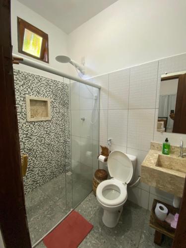 a bathroom with a toilet and a shower and a sink at Apartamentos Terra Mar in Trancoso