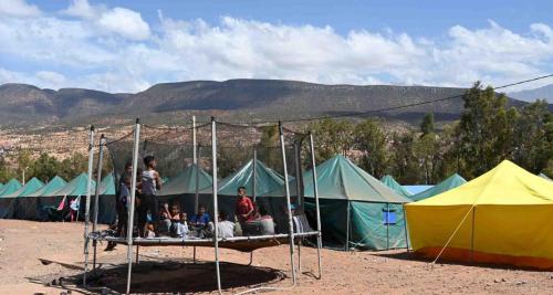 un groupe de personnes assises sur un lit devant des tentes dans l'établissement خيام للكراء ومكان رائع, à Agadir