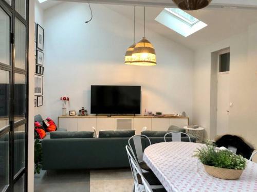 a living room with a green couch and a table at La maison de Félix. Maison de bord de Loire. in Chalonnes-sur-Loire