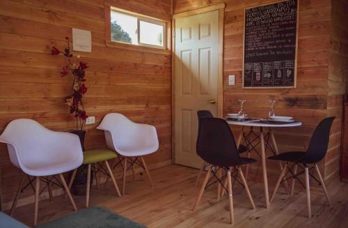 a dining room with wooden walls and a table and chairs at Tiny House con opción de tina temperada in Puerto Varas