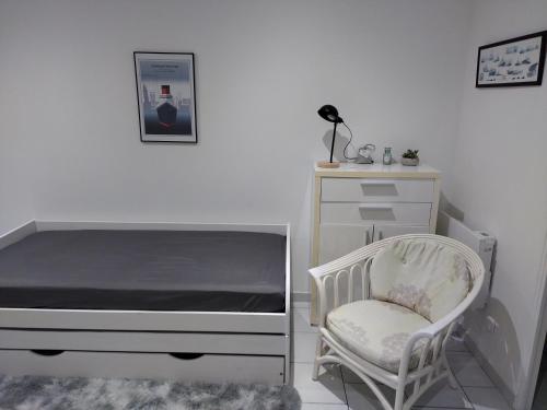 a bedroom with a bed and a chair and a dresser at studio charmant canapé lit Netflix Prime video wifi in Le Havre
