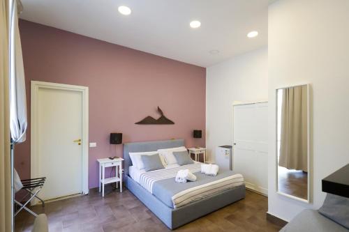 una camera con letto e parete rosa di Boutique Toledo a Napoli