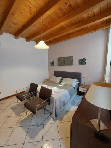 1 dormitorio con 1 cama, mesa y sillas en Bed & Breakfast Monti 85 en San Colombano al Lambro