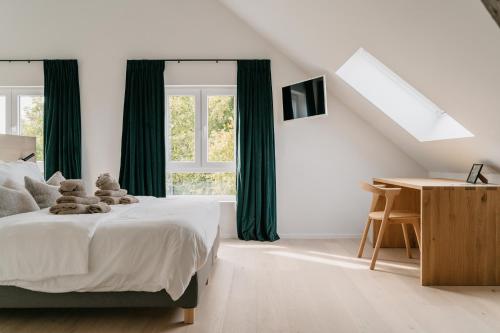 1 dormitorio con 1 cama con cortinas verdes y escritorio en MAM Haspengouw en Sint-Truiden