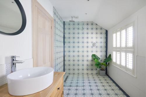 a bathroom with a white sink and a mirror at The Sea House Beautiful Large Whitstable Home With Sea Views in Kent