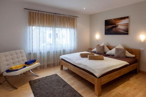 ein Schlafzimmer mit einem großen Bett und einem Stuhl in der Unterkunft Baalmann Nr.4 in Borkum