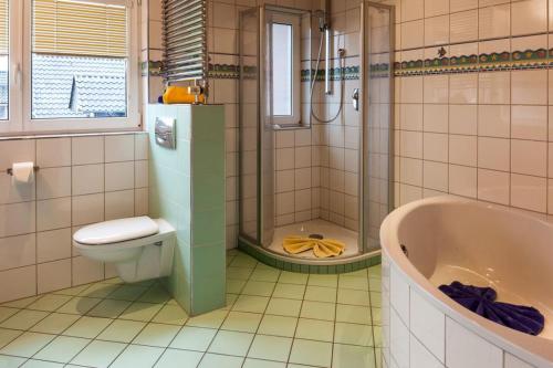 ein Badezimmer mit einer Badewanne, einem WC und einem Waschbecken in der Unterkunft Baalmann Nr.4 in Borkum